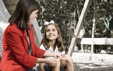 an education provider applies a bandage to the knee of an appreciative child